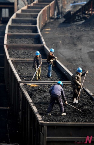 Workers load coal onto a train in Jiujiang, east China's Jiangxi Province, Feb. 8, 2012.