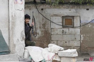 A Free Syrian Army (FSA) fighter takes cover as FSA exchange fire with Syrian army forces in Idlib, Syria, Feb. 13, 2012. (Photo DB: Xinhua/Nasser Nouri)