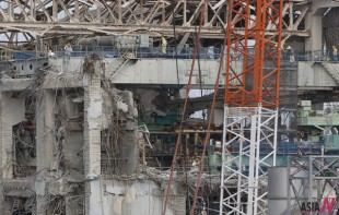 Workers wearing protective suits and masks work atop of No.4 reactor building of Tokyo Electric Power Co. (TEPCO)'s tsunami-crippled Fukushima Daiichi nuclear power plant in Fukushima prefecture, Japan, Feb. 20, 2012. (Photo: Xinhua>