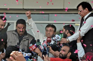 Former Pakistani President Pervez Musharraf, center, gestures to his supporters, unseen, upon his arrival to Karachi airport, Pakistan, Sunday, March 24, 2013. (Photo : AP Photo/NEWSis/S.I. Ali)