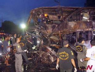 Rescue workers look for more bodies in the charred wreckage of a double-decker passenger bus after an accident in Saraburi province, northeast of Bangkok, Thailand Tuesday, July 23, 2013. The bus caught fire after colliding with a truck early on Tuesday, killing 19 people and injuring 20 others, authorities said. (AP Photo/Daily News) THAILAND OUT