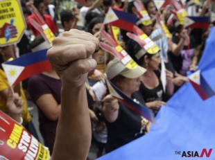 Protesters wave Philippine flags during a rally at the Chinese Consulate at the financial district of Makati city, east of Manila, Philippines to protest alleged bullying by China in the current row over the Spratlys Group of islands in the South China Sea Wednesday July 24, 2013. The protesters, under the newly-formed West Philippine Sea Coalition (WSPC), urged the Chinese government to stop alleged intrusions into the West Philippine Sea and should act like a "good neighbor" to other countries in the region. (AP Photo/Bullit Marquez)