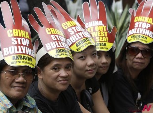 Protesters wear headgears during a rally at the Chinese Consulate at the financial district of Makati city, east of Manila, Philippines to protest alleged bullying by China in the current row over the Spratlys Group of islands in the South China Sea Wednesday July 24, 2013. The protesters, under the newly-formed West Philippine Sea Coalition (WSPC), urged the Chinese government to stop alleged intrusions into the West Philippine Sea and should act like a "good neighbor" to other countries in the region. (AP Photo/Bullit Marquez)