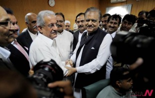 Mamnoon Hussain, center right, a candidate from  ruling party Pakistan Muslim League-N shakes hands with Raza Rabbani, a candidate from opposition party Pakistan People Party after submitting their nomination papers for upcoming presidential election in Islamabad, Pakistan, Wednesday, July 24, 2013. Pakistani political parties have nominated their candidates for the upcoming presidential elections with the ruling party's candidate seen as the front-runner. (AP Photo/Anjum Naveed)