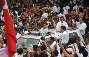 Myanmar Opposition Leader Aung San Suu Kyi, center, greets supporters from a vehicle after she attended a ceremony at her party headquarters in Yangon, Myanmar, Friday, Sept 27, 2013. Suu Kyi attended the ceremony to mark the 25th anniversary of her party, National League for Democracy (NEWSis/AP)