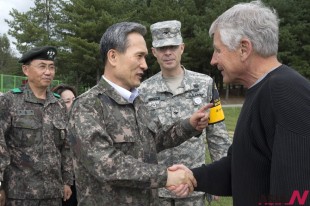 U.S. Secretary of Defense Chuck Hagel, right, is greeted by South Korean Defense Minister Kim Kwan-jin, before a tour of the Demilitarized Zone (DMZ), the military border separating the two Koreas, in Panmunjom, South Korea, on Monday, Sept. 30, 2013. Looking on them between Hagel and Kim is U.S. Army Col. James Minnich. (NEWSis/AP)