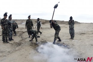 In this picture released by Tasnim News Agency on Wednesday, Nov. 20, 2013, members of Iran's paramilitary Basij force, which is controlled by the Revolutionary Guard, attend a maneuver of preparation for possible attack on Iran's nuclear sites, next to the nuclear power plant in Bushehr, southern Iran. (AP/NEWSis)