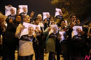 In this photo released by the Iranian Students News Agency, ISNA, Iranians hold posters of President Hassan Rouhani as they welcome Iranian nuclear negotiators upon their arrival from Geneva at the Mehrabad airport in Tehran, Iran, Sunday, Nov. 24, 2013. Hundreds of cheering supporters greeted Iran's nuclear negotiators as they arrived back to Tehran late Sunday night. Tehran agreed Sunday to a six-month pause of its nuclear program while diplomats continue talks. International observers are set to monitor Iran's nuclear sites as the West eases about $7 billion of the economic sanctions crippling the Islamic Republic. (AP/NEWSis)