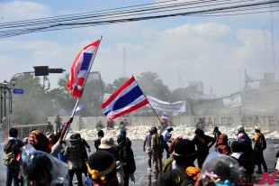 Anti-government protesters rally outside the Government House in Bangkok, Thailand, Dec. 1, 2013. Thai police on Sunday fired tear gas to drive back hordes of anti-government Thai protesters trying to break barricades into varied government premises in the capital on Sunday. (Xinhua/NEWSis)