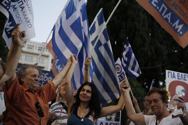 Supporters of the No vote dance at Syntagma square in Athens, Sunday, July 5, 2015. Greece faced an uncharted future as its interior ministry predicted Sunday that more than 60 percent of voters in a hastily called referendum had rejected creditors' demands for more austerity in exchange for rescue loans. (AP Photo)