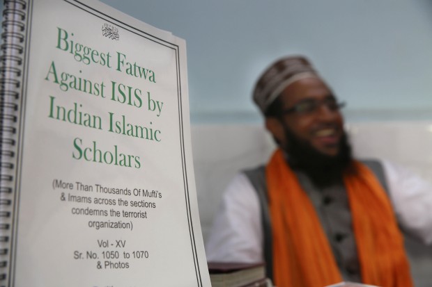 Indian Muslim cleric Mohammed Manzar Hasan Ashrafi Misbahi, right speaks with the Associated Press during an interview at  at the Ajmeri Masjid in Mumbai, India, Wednesday, Sept. 9, 2015. More than 1,000 Muslim clerics in India have ratified a religious ruling that condemns the Islamic State and calls the extremist group's actions "un-Islamic, Misbahi said Wednesday.A copy of the edict, or fatwa is on left. (AP Photo/Rafiq Maqbool)