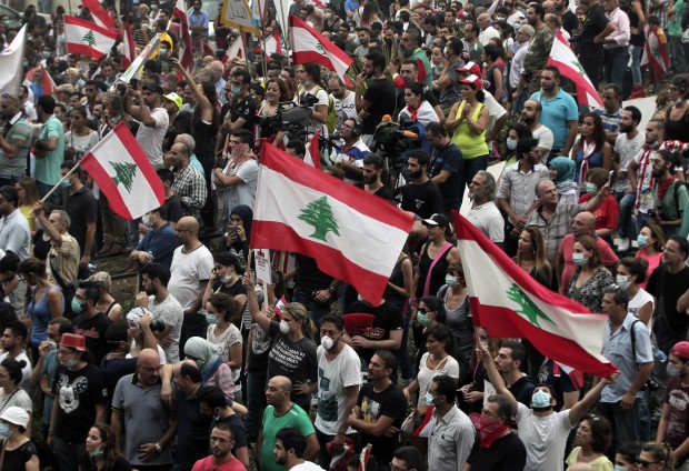 Lebanese anti-government protesters shout slogans as they hold their national flags, during a protest against the on-going trash crisis and government corruption, in downtown Beirut, Lebanon, Wednesday, Sept. 9, 2015. Lebanon's prime minister says he hopes that political talks between senior politicians will help end government paralysis that has sparked angry street protests. (AP Photo/Bilal Hussein) 