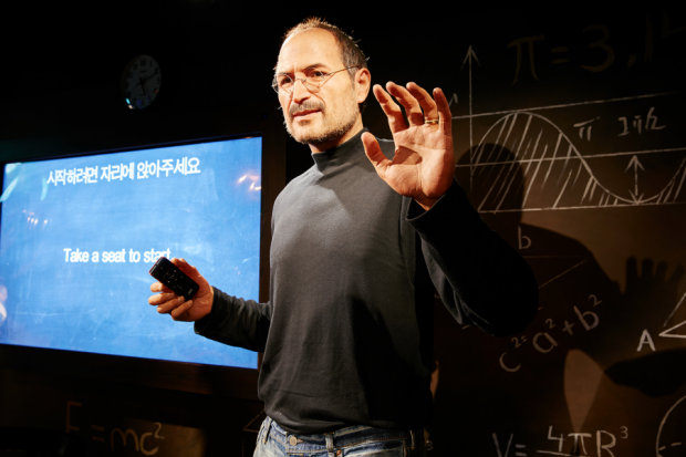 Steve Jobs stands in front of an interactive screen testing people's minds.