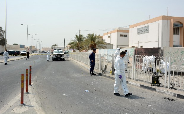 Policemen inspect the site of a roadside bombing in Sitra village, near Manama, Bahrain. (Xinhua/Bahrain News Agency) 