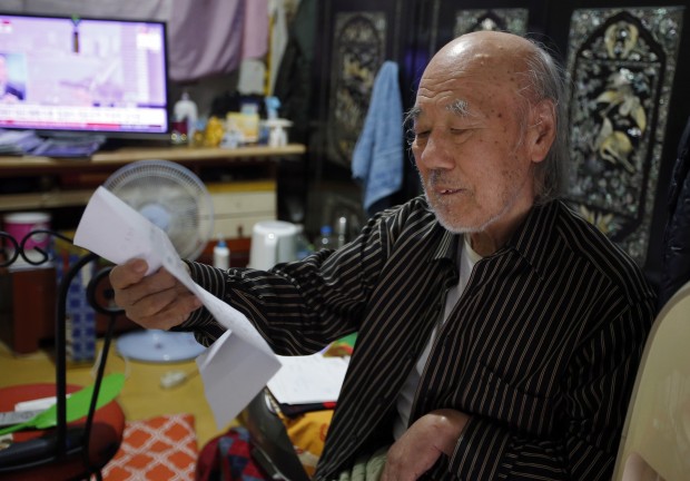 South Korean Kim Wu-jong, 87, who will travel to North Korea to meet his younger sister, looks at a document from the Red Cross during the interview at his home in Seoul, South Korea. Kim and about 640 other South Koreans will meet their North Korean relatives at the authoritarian country?s scenic Diamond Mountain resort in a reunion program that begins Tuesday, Oct. 20. Tens of thousands of people on both sides of the Demilitarized Zone desperately seek such reunions, but the two countries have pulled off relatively few of them. (AP Photo/Lee Jin-man)  