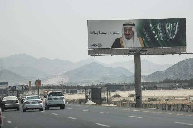 a banner that displays the image of Saudi King Salman along with the phrase "Salman, we hear and obey," near Mecca, Saudi Arabia. A drop in oil revenue is forcing Saudi Arabia to weigh its first cuts to welfare and investment in years. (AP Photo/Mosa'ab Elshamy) 