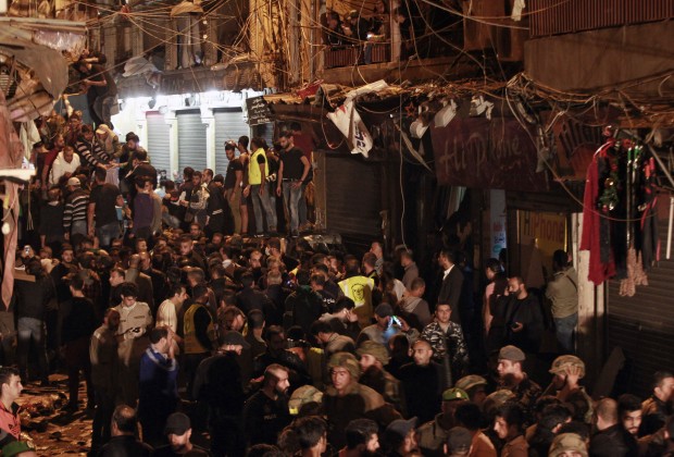 Lebanese army and civilians gather near the site of a twin suicide attack in Burj al-Barajneh, southern Beirut, Lebanon, Thursday, Nov. 12, 2015 that struck a Shiite suburb killed and wounded dozens, a Lebanese official said. (AP Photo/Bilal Hussein)  