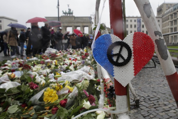 Flowers and candles placed  in front of the French embassy for the victims killed in the Friday's attacks in Paris, France, near the Brandenburg Gate in Berlin, Sunday, Nov. 15, 2015. Multiple attacks across Paris on Friday night have left scores dead and hundreds injured.  (AP Photo/Markus Schreiber)