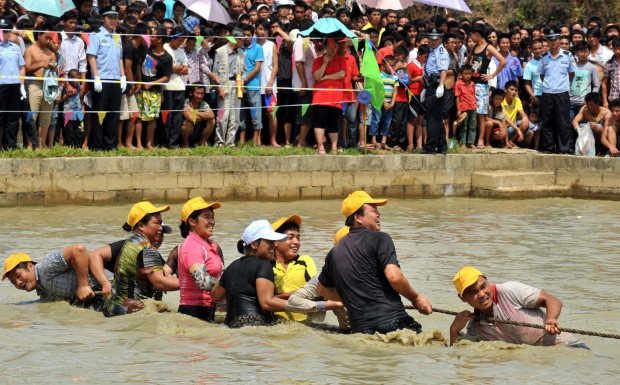 Locals play tug-of-war in a mud games held in Luolong Village of Mojiang Hani Autonomous County, southwest China's Yunnan Province, May 2, 2014. Both the locals and tourists joined in a number of competitive but fun events in Friday's mud games. (Xinhua/Chen Haining) 