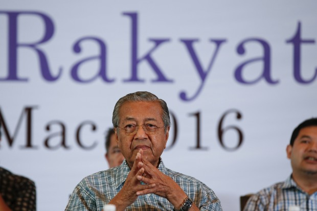 Malaysia's former Prime Minister Mahathir Mohamad prays with opposition leaders as they attend the "Peoples Congress 2016" event in Shah Alam, Malaysia, Sunday, March 27, 2016. Mahathir and United Malays National Organization (UMNO) leaders gathered to urge Prime Minister Najib Razak to resign over corruption allegations. (AP Photo/Vincent Thian)