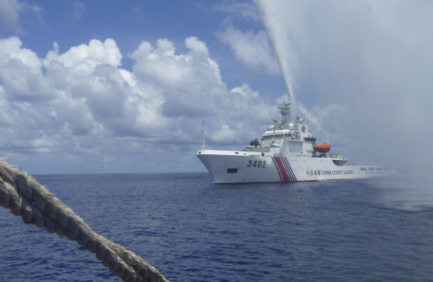 FILE - In this Sept. 23, 2015, file photo, Chinese Coast Guard members approach Filipino fishermen as they confront each other off Scarborough Shoal in the South China Sea, also called the West Philippine Sea. The Philippines' new president said Tuesday July 5, 2016, that Manila is ready to talk to China, not go to war, if an arbitration tribunal rules in its favor in a case it brought against Beijing's claims in the South China Sea. (AP Photo/Renato Etac, File)