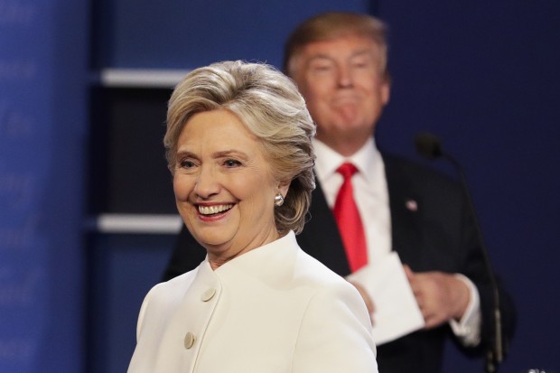 Democratic presidential nominee Hillary Clinton walks off stage as Republican presidential nominee Donald Trump puts his notes away after the third presidential debate at UNLV in Las Vegas, Wednesday, Oct. 19, 2016. (AP Photo/John Locher)