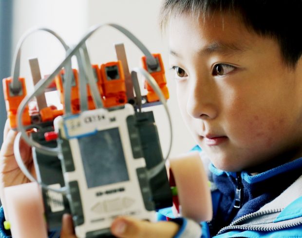 A student debugs a robot at a programming contest for youngsters held in Suzhou, east China's Jiangsu Province, December 12, 2018. (Photo by Hua Xuegen from People’s Daily Online)