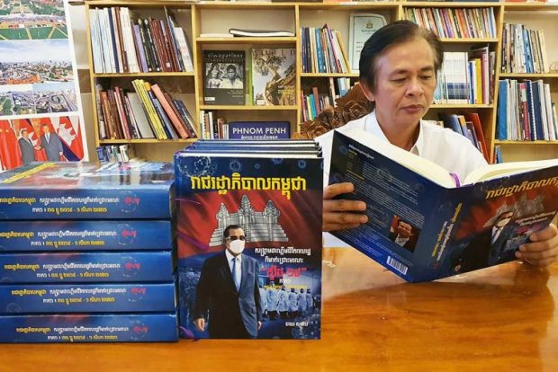 Chhay Sophal with his latest book - a historical record of Cambodia's fight against COVID-19